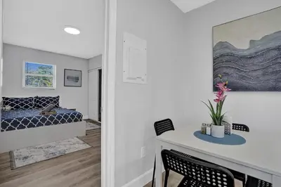 a bedroom with a bed and a table with chairs at The Front Wave Luxury Home in Fort Lauderdale