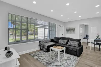 a living room with a black couch and a table at The Front Wave Luxury Home in Fort Lauderdale