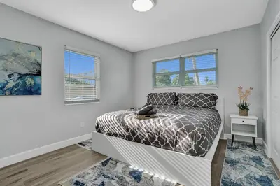 a bedroom with a bed and two windows at The Front Wave Luxury Home in Fort Lauderdale