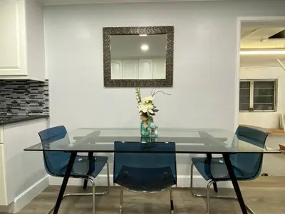 a dining room table with blue chairs and a mirror at Luxury home in Fort Lauderdale