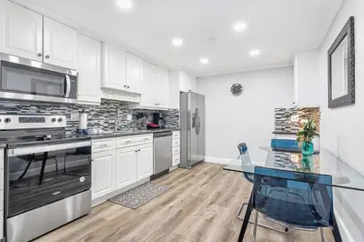 a kitchen with white cabinets and stainless steel appliances at Luxury home in Fort Lauderdale