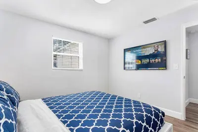 a bedroom with a bed and a tv on the wall at Luxury home in Fort Lauderdale