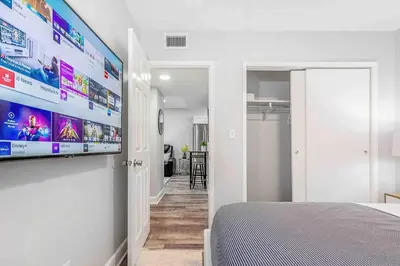a bedroom with a large flat screen tv on a wall at Mazor Luxury Two bedroom vacation Home in Fort Lauderdale