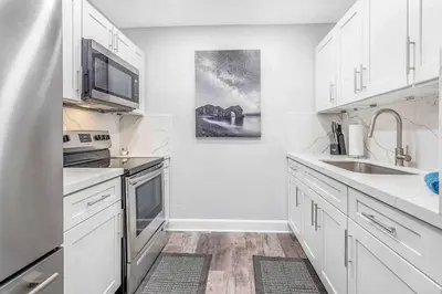 a kitchen with white cabinets and a sink at Mazor Luxury Two bedroom vacation Home in Fort Lauderdale