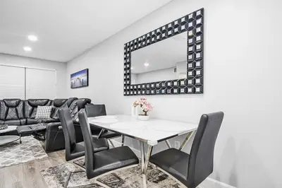 a dining room with a table and chairs and a mirror at Rachaels Upscale Two Bedrooms Luxury Home in Fort Lauderdale