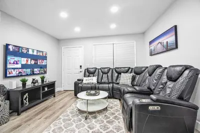 a living room with a black leather couch at Rachaels Upscale Two Bedrooms Luxury Home in Fort Lauderdale