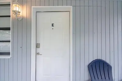 a blue chair sitting in front of a white door at Rachaels Upscale Two Bedrooms Luxury Home in Fort Lauderdale