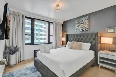 a bedroom with a large white bed and windows at Cozy Beachfront 2 BDR Miami Beach Condo 1114 in Miami Beach