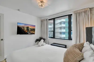a bedroom with a white bed and a window at Cozy Beachfront 2 BDR Miami Beach Condo 1114 in Miami Beach