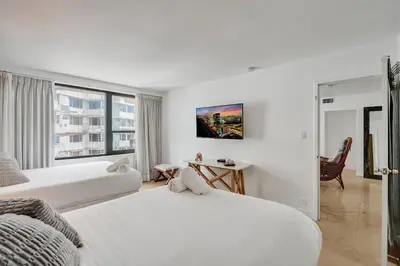 a white hotel room with two beds and a window at Cozy Beachfront 2 BDR Miami Beach Condo 1114 in Miami Beach