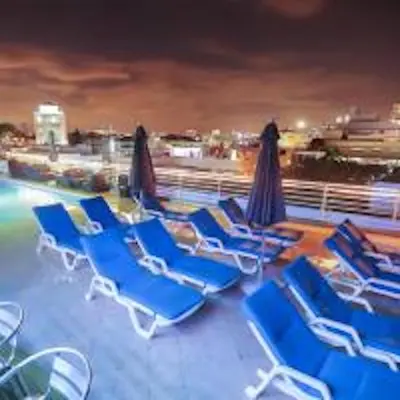 a group of blue lounge chairs and umbrellas on a pool at Congress Ocean Drive in Miami Beach