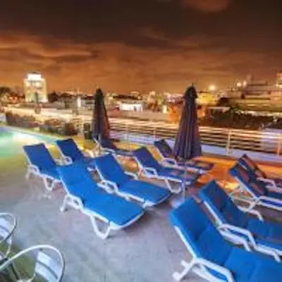 a group of lounge chairs and umbrellas next to a pool at Congress Ocean Drive in Miami Beach