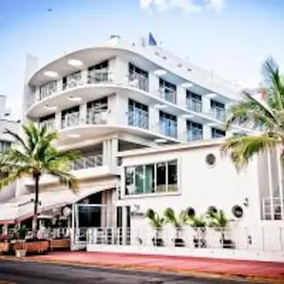 a white building with palm trees in front of it at Congress Ocean Drive in Miami Beach