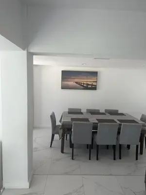 a dining room with a table and chairs and a painting at Pool house 3 bedroom 2 bathroom in North Miami Beach