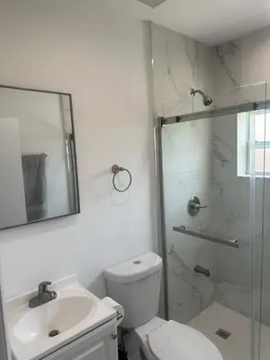 a bathroom with a shower and a toilet and a sink at Pool house 3 bedroom 2 bathroom in North Miami Beach