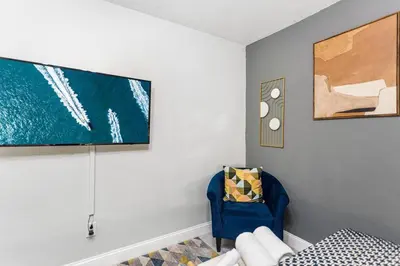 a living room with a blue chair and a painting at The Brickell Hideout - Charming/Cozy/Central in Miami