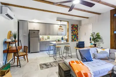 a living room with a couch and a kitchen at The Brickell Hideout - Charming/Cozy/Central in Miami
