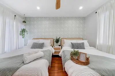 two beds sitting next to each other in a bedroom at Westchester Garden in Miami