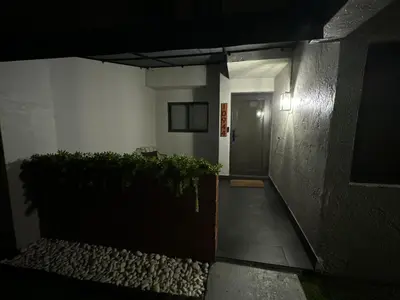 a hallway leading to a door of a building at night at Westchester Garden in Miami