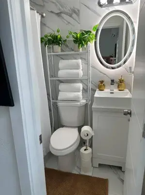 a bathroom with a toilet and a mirror and towels at Villa Clara Gold-Little Havana in Miami