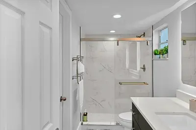 a white bathroom with a shower and a toilet at One Bedroom Steps Away From The Beach! in Sunny Isles Beach
