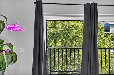 a window with gray curtains and a balcony at One Bedroom Steps Away From The Beach! in Sunny Isles Beach