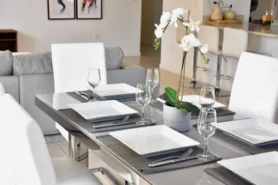 a dining room table with white plates and glasses at 515-Trendy 2Bd2Ba Midtown HUGE private patio! in Miami