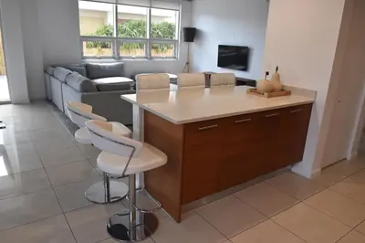 a kitchen with a large island in a living room at 515-Trendy 2Bd2Ba Midtown HUGE private patio! in Miami