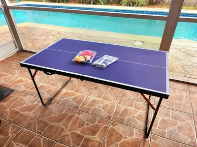 a purple table with two magazines on it next to a pool at Amazing 5 Bedroom Pool Home - Minimum 28 days Stay Only Great Location! in Miramar