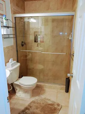 a bathroom with a shower with a toilet and a sink at Amazing 5 Bedroom Pool Home - Minimum 28 days Stay Only Great Location! in Miramar