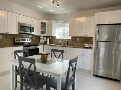 a kitchen with a white table and chairs and a refrigerator at Apartments Little Habana near calle 8 in Miami