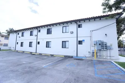 a large white building with a parking lot at Apartments Little Habana near calle 8 in Miami
