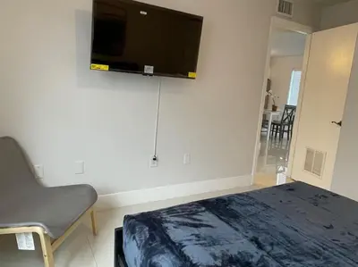 a bedroom with a bed and a flat screen tv on the wall at Apartments Little Habana near calle 8 in Miami