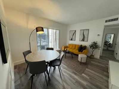 a living room with a table and a yellow couch at Remodeled Little Havanna Apartments great location in Miami