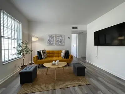 a living room with a yellow couch and a table at Remodeled Little Havanna Apartments great location in Miami