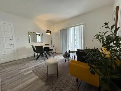 a living room with a yellow couch and a table at Remodeled Little Havanna Apartments great location in Miami