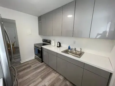 a white kitchen with a sink and a microwave at Remodeled Little Havanna Apartments great location in Miami