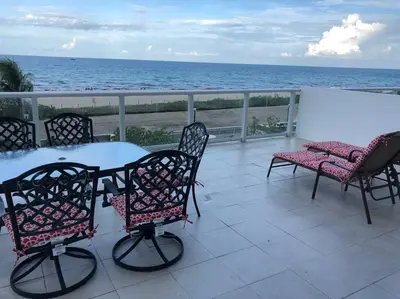 a patio with a table and chairs and the ocean at Beautiful Pavilion in Miami Beach