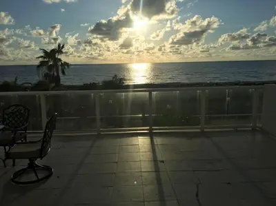 a view of the ocean from a balcony with a sunset at Beautiful Pavilion in Miami Beach