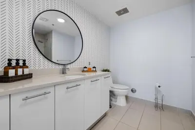 a white bathroom with a sink and a mirror at 516-2Bd2Ba Midblock Apartment FREE parking in Miami