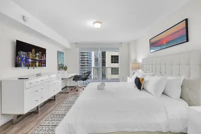 a white bedroom with a large white bed and a desk at Brickell Key Gem: Stylish 1-Bed W/ Free Parking in Miami