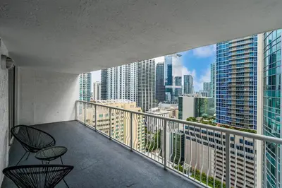 a balcony with two chairs and a view of a city at Brickell Key Gem: Stylish 1-Bed W/ Free Parking in Miami