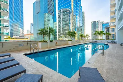 a swimming pool on the roof of a building with tall buildings at Brickell Key Gem: Stylish 1-Bed W/ Free Parking in Miami