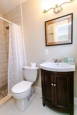 a bathroom with a toilet and a sink and a mirror at Best Area Spacious 4BR Heated Pool Mins To Beach in Hollywood