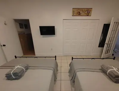 two beds in a room with a garage at Walk to Hard Rock ~ Amazing 5 Star Home Away From Home! in Miami Gardens