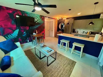 a living room with a couch and a kitchen at MiamiVice Las Olas Near Beach and Park w Fire Pit in Fort Lauderdale