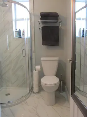 a bathroom with a toilet and a glass shower at Ocean Breeze Studio With Parking By The Beach in Miami Beach