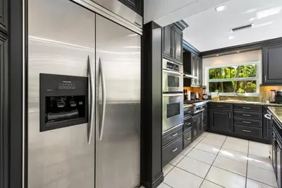 a kitchen with stainless steel appliances and black cabinets at The Wellness Retreat- Amazing Amenities Near Beach in Hollywood