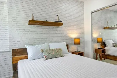 a bedroom with a large white bed and a brick wall at The Wellness Retreat- Amazing Amenities Near Beach in Hollywood