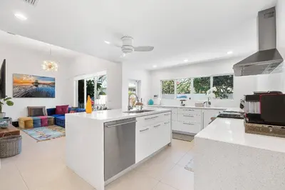 a kitchen with white appliances and a living room at Sea La Vie FL in Fort Lauderdale